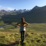 Una ragazza fotografata di spalle su Kirkjufell in viaggio in solitaria. Scopri tutti i tour privati di Elysia Tours.